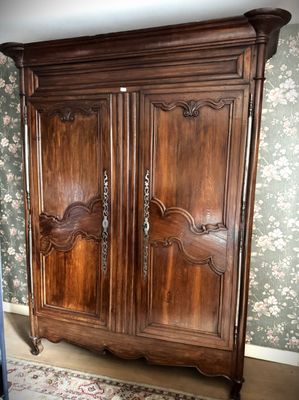 a large wooden armoire in the corner of a room