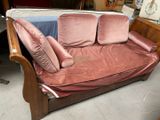un canapé rose avec des coussins dessus, dans une pièce