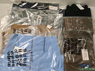 trois paires de chaussettes pour homme et un t-shirt dans un sac en plastique