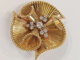 a close up of a gold brooch with diamonds on it