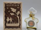 a small bottle of perfume sitting next to a box