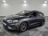 Une Ford Focus grise est garée sur un sol à damier.