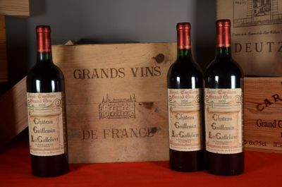 three bottles of red wine sitting next to a wooden box
