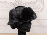 black fur hat on a mannequin head on a wooden table