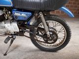 a blue and black motorcycle parked in front of a brick wall