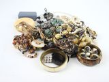 a pile of assorted jewelry on a white surface