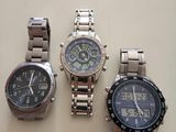 three watches are sitting on a table next to each other