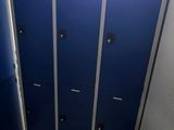 une rangée de casiers bleus dans des toilettes publiques