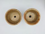 two brown vases sitting on top of a white table next to each other