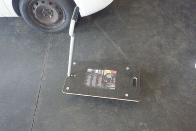 un petit appareil électronique posé par terre à côté d'une voiture