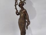 an antique bronze vase with a woman holding a flower