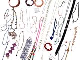 many necklaces and bracelets laid out on a white surface