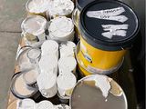 many cans of paint and cans of paint sitting on a box