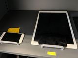 two tablet computers and a cell phone on a table