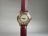 une image montrant un gros plan d'une montre-bracelet avec un bracelet rouge