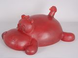 un cochon rouge couché sur une surface blanche