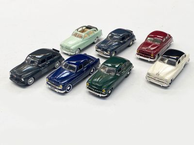 plusieurs petites voitures sont alignées sur une surface blanche