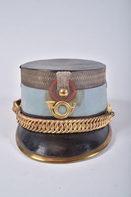 un chapeau entouré d'une chaîne, posé sur une surface blanche