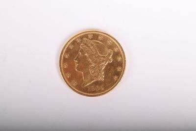 gros plan d'une pièce d'or sur une surface blanche