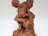 statue of a woman sitting on a rock holding a bunch of grapes