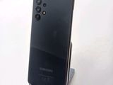 a black samsung phone on a stand on a white surface