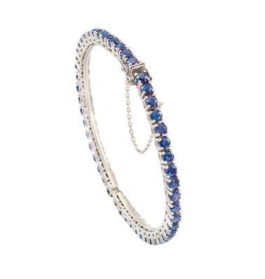 un gros plan d'un bracelet orné de pierres bleues sur fond blanc