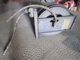 une machine posée à même le sol, à laquelle est raccordé un tuyau