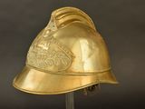 a gold helmet on a stand on a black background