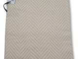une couverture beige et blanche ornée d'un motif en chevrons