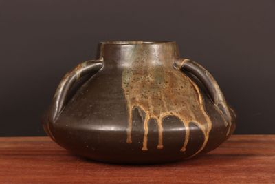 un vase marron orné d'une girafe, posé sur une table