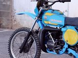 a blue dirt bike parked in front of a building