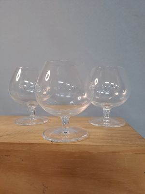 quatre verres à vin vides posés sur une table en bois