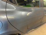a silver car that has been dented and is parked in a garage
