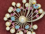 a brooch with pearls and crystals on a red cloth