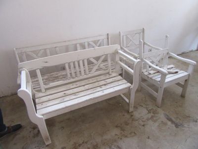 un banc blanc et deux chaises dans une pièce
