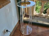 une table en verre sur laquelle est posé un livre, devant une fenêtre