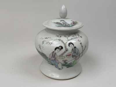 un vase blanc avec un tableau sur une table