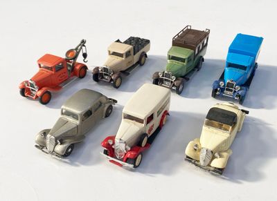 plusieurs petites voitures sont alignées sur une surface blanche