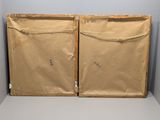 two pieces of brown paper sitting on top of a white table
