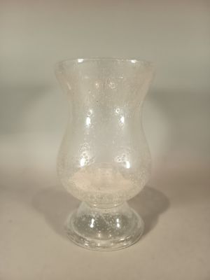 a small glass vase sitting on a white surface