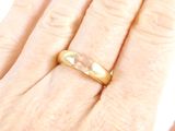 a woman ' s hand with a gold ring on it