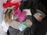 a pile of clothes and shoes on a bed
