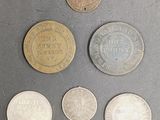 six different coins are shown on a gray surface