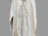 a white shirt hanging on a wooden hanger on a gray wall