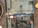 une boîte à outils contenant un marteau et d'autres outils, posée par terre