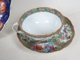a cup and saucer sitting on a table next to a bowl