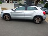 the silver car is parked on the side of the road in the parking lot