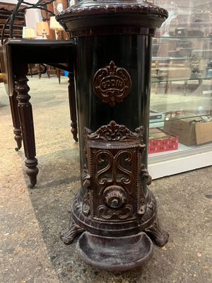 une très vieille horloge posée sur une table devant une vitrine