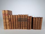 plusieurs vieux livres sont empilés sur une surface blanche