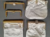 three white purses with gold trims and a chain around them